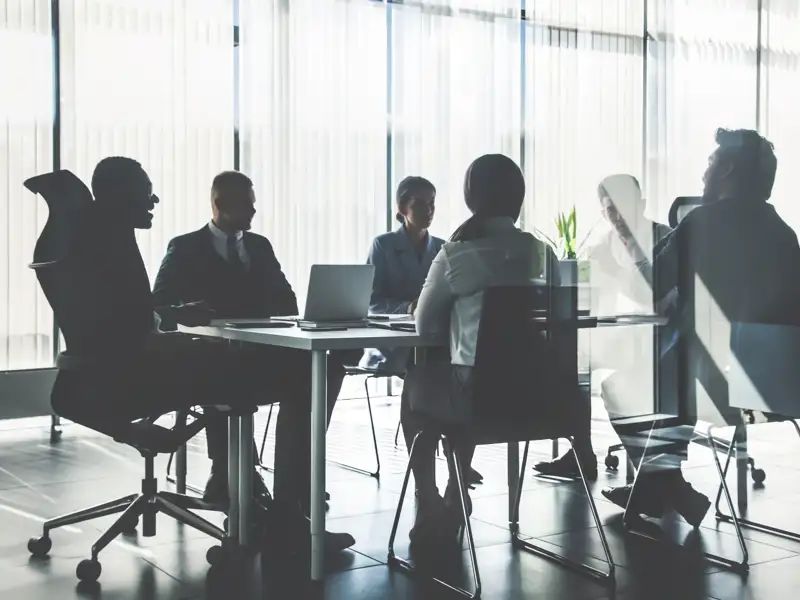 Coworkers meeting in a glass office room.