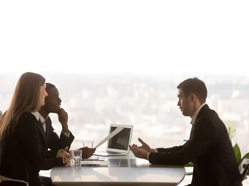 Coworkers meeting in front of a glass window.